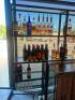 DESCRIPTION 9' THREE-SECTION CUSTOM METAL RACK WITH GLASS INSERT SHELVING, DESIGNED FOR BACK BAR BOTTLE DISPLAY. BUILT TO FIT AN 84" BACK BAR COOLER O - 2