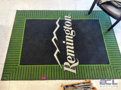 DESCRIPTION 7' X 5' "REMINGTON" LOGO AREA RUG IN GREEN AND BLACK W/ WHITE LETTERING LOCATION ENTRANCE QTY 1