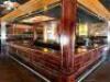 22' X 18' VINTAGE HARDWOOD BAR WITH RICH PANEL DETAILING IMPRESSIVE U-SHAPED BAR CONSTRUCTED OF SOLID HARDWOOD WITH DEEP, DARK FINISH AND ELEGANTLY CRAFTED PANELING. FEATURES A STAINED GLASS CEILING INSET ABOVE, MULTIPLE SERVICE STATIONS, AND AMPLE COUNTE