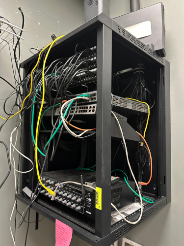 WALL MOUNTED ELECTRONICS CABINET W/ CONTENTS.