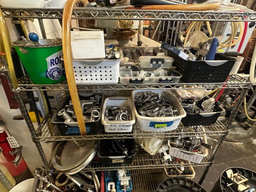 CONTENTS OF SHELF - CLAMPS, O RINGS, AND MISC BREWERY EQUIPMENT HARDWARE.