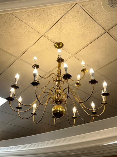 MULTI-ARM BRASS CHANDELIER WITH CANDLE-STYLE LIGHT SOCKETS AND POLISHED METAL FINISH. TRADITIONAL DESIGN WITH CURVED ARMS AND CENTRAL BALL ACCENT.