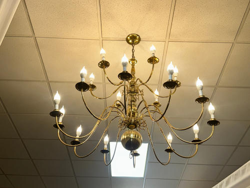MULTI-ARM BRASS CHANDELIER WITH CANDLE-STYLE LIGHT SOCKETS AND POLISHED METAL FINISH. TRADITIONAL DESIGN WITH CURVED ARMS AND CENTRAL BALL ACCENT.