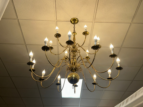 MULTI-ARM BRASS CHANDELIER WITH CANDLE-STYLE LIGHT SOCKETS AND POLISHED METAL FINISH. TRADITIONAL DESIGN WITH CURVED ARMS AND CENTRAL BALL ACCENT.