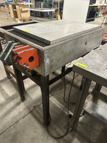 STEEL WORK TABLE WITH INTEGRATED GRID TOP AND REMOVABLE STEEL PLATE SURFACE.