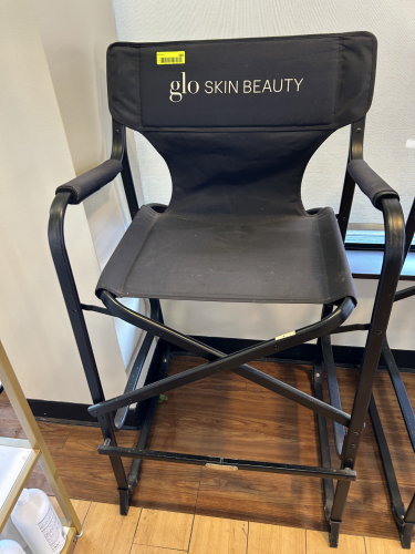 GLŌ MINERALS BRANDED DIRECTOR&rsquo;S CHAIR WITH BLACK CANVAS SEAT AND BACK, PADDED ARMRESTS, AND FOLDING METAL FRAME.