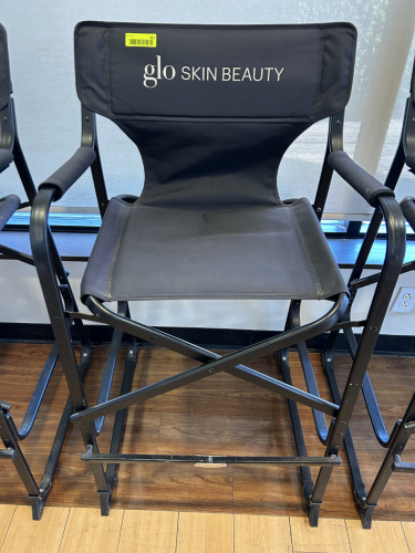 GLŌ MINERALS BRANDED DIRECTOR&rsquo;S CHAIR WITH BLACK CANVAS SEAT AND BACK, PADDED ARMRESTS, AND FOLDING METAL FRAME.