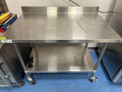 REGENCY 48" X 30" STAINLESS TABLE W/ BACK SPLASH.