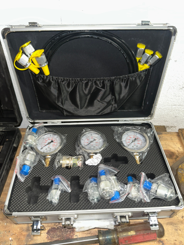 HYDRAULIC PRESSURE TEST KIT WITH MULTIPLE GAUGES, HOSES, AND ADAPTER FITTINGS IN ALUMINUM STORAGE CASE.