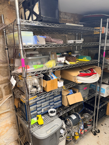 CONTENTS OF SHELF - ASSORTED HARDWARE, TOOLING, AND PARTS.