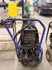 EASTWOOD TIG WELDER PACKAGE MOUNTED ON MOBILE CART WITH GAS CYLINDER, REGULATOR, TORCH, AND LEADS. CONTROL PANEL FEATURES ADJUSTABLE SETTINGS FOR POWER, CLEARANCE EFFECT, PRE FLOW, AND POST FLOW WITH AC/DC SELECTION. - 2