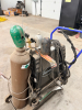 EASTWOOD TIG WELDER PACKAGE MOUNTED ON MOBILE CART WITH GAS CYLINDER, REGULATOR, TORCH, AND LEADS. CONTROL PANEL FEATURES ADJUSTABLE SETTINGS FOR POWER, CLEARANCE EFFECT, PRE FLOW, AND POST FLOW WITH AC/DC SELECTION. - 5