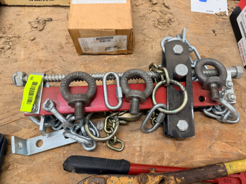 HEAVY-DUTY LOAD BINDER / LIFTING SPREADER BAR ASSEMBLY WITH CHAINS, EYE BOLTS, AND ADJUSTABLE THREADED ROD. INCLUDES MULTIPLE RATED LIFTING POINTS (M16 EYE BOLTS MARKED ~1 TON WLL), SHACKLES, AND MOUNTING HARDWARE