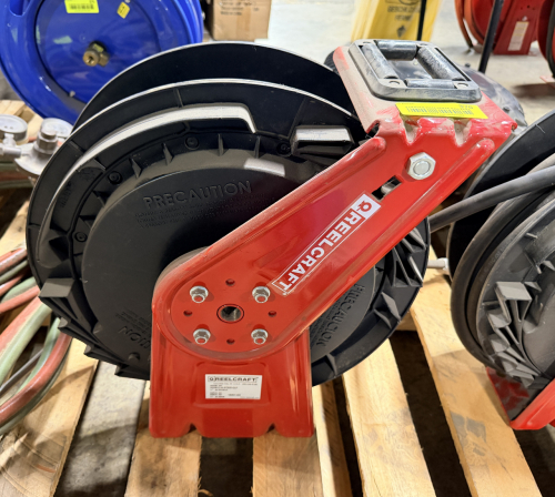 REELCRAFT SPRING RETRACTABLE HOSE REEL WITH HEAVY DUTY BASE AND SWIVEL MOUNT. UNIT FEATURES INDUSTRIAL GRADE CONSTRUCTION WITH BLACK DRUM AND RED FRAME.