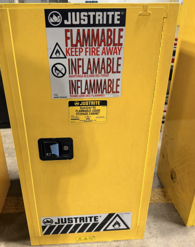 JUSTRITE SURE-GRIP EX FLAMMABLE LIQUID STORAGE CABINET WITH SINGLE DOOR AND LOCKING HANDLE. UNIT FEATURES STEEL CONSTRUCTION WITH ADJUSTABLE INTERIOR SHELF SUPPORTS AND SAFETY LABELING.