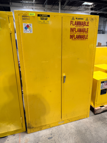 JUSTRITE FLAMMABLE LIQUID STORAGE CABINET WITH DOUBLE DOORS AND ADJUSTABLE INTERIOR SHELVING.