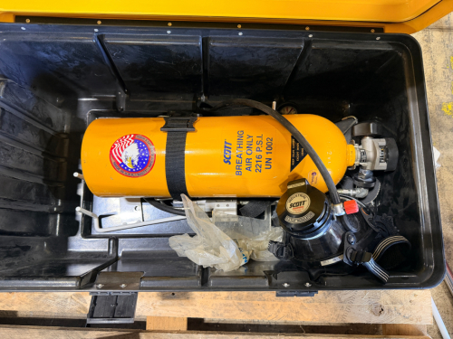 SELF-CONTAINED BREATHING APPARATUS WITH AIR CYLINDER, MASK, AND REGULATOR ASSEMBLY IN HARD CASE. INCLUDES HARNESS, HOSE CONNECTIONS, AND PRESSURE GAUGE AS SHOWN.