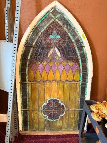TWO-PIECE ANTIQUE LEADED STAINED GLASS WINDOW SET CONSISTING OF A GOTHIC ARCH PANEL AND MATCHING RECTANGULAR PANEL, FEATURING MULTI-COLORED TEXTURED GLASS WITH GEOMETRIC AND FLORAL MOTIFS INCLUDING A CENTRAL FLEUR-DE-LIS STYLE DESIGN AND LOWER QUATREFOIL 