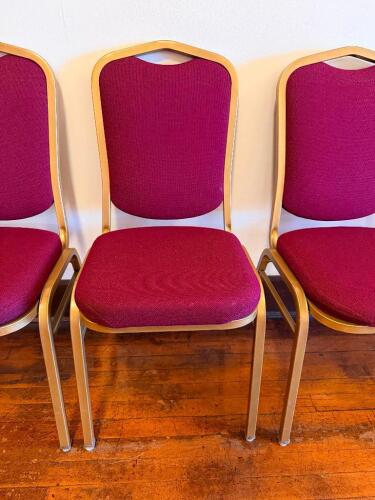 (8) MAROON UPHOLSTERED STACK CHAIRS W/ GOLD COLORED METAL FRAME.
