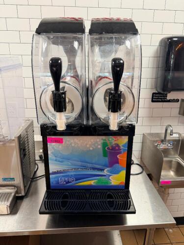 IPRO DOUBLE BOWL FROZEN BEVERAGE / SLUSH MACHINE WITH CLEAR HOPPERS, DUAL DISPENSING HANDLES, AND FRONT DRIP TRAY.