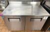 TRUE STAINLESS STEEL WORKTOP REFRIGERATOR WITH BACKSPLASH AND DOUBLE DOOR STORAGE COMPARTMENT. UNIT FEATURES SOLID DOORS WITH INTERNAL SHELVING AND REAR MOUNTED REFRIGERATION SYSTEM. - 2