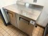 TRUE STAINLESS STEEL WORKTOP REFRIGERATOR WITH BACKSPLASH AND DOUBLE DOOR STORAGE COMPARTMENT. UNIT FEATURES SOLID DOORS WITH INTERNAL SHELVING AND REAR MOUNTED REFRIGERATION SYSTEM. - 2