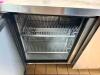 TRUE STAINLESS STEEL WORKTOP REFRIGERATOR WITH BACKSPLASH AND DOUBLE DOOR STORAGE COMPARTMENT. UNIT FEATURES SOLID DOORS WITH INTERNAL SHELVING AND REAR MOUNTED REFRIGERATION SYSTEM. - 3