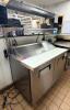 TRUE STAINLESS STEEL SANDWICH PREP TABLE WITH RAISED INGREDIENT RAIL AND DOUBLE DOOR REFRIGERATED BASE. UNIT INCLUDES OVERHEAD SHELF ASSEMBLY AND CUTTING SURFACE WITH LIFT-UP LID.