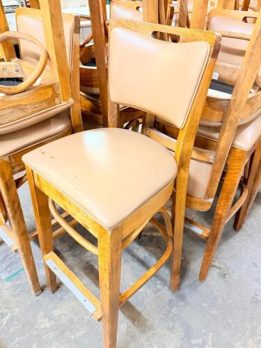 (15) BLONDE WOOD BAR STOOLS W/ TAN VINYL SEATS. FAIR TO POOR CONDITION.