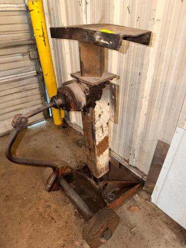 MECHANICAL RATCHET JACK WITH STEEL FRAME, CRANK HANDLE OPERATION, AND FLAT LOAD PLATFORM. SOLID BASE WITH WHEELS FOR POSITIONING