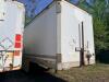 24' DRY VAN TRAILER BODY WITH ROLL-UP REAR DOOR, WOOD INTERIOR WALLS, WOOD FLOORING, AND STEEL FRAME CONSTRUCTION. UNIT SHOWS HEAVY WEAR INCLUDING RUST, CORROSION, SIDE PANEL DAMAGE, AND WEATHERING. REAR LIGHTING PRESENT, SINGLE AXLE CONFIGURATION, AND EX - 3