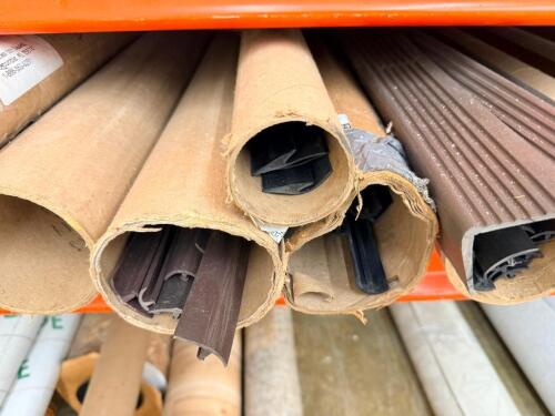 ASSORTMENT OF VINYL FLOORING TRANSITION STRIPS AND TRIM PIECES, VARIOUS PROFILES AND COLORS INCLUDING BROWN, GRAY, AND BLACK, STORED IN CARDBOARD TUBES, MIXED LOT