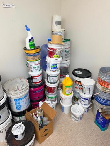 CONTENTS OF CORNER - ASSORTED SEALANT, ADHESIVES, AND CHEMICALS. PARTIAL TO FULL.