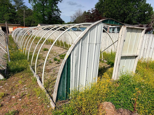 HOOP STYLE METAL GREEN HOUSES WITH PARTIAL PANEL ENCLOSURE AND DOUBLE DOOR END, ARCHED STEEL RIB CONSTRUCTION