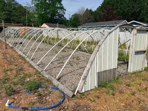 HOOP STYLE METAL GREEN HOUSES WITH PARTIAL PANEL ENCLOSURE AND DOUBLE DOOR END, ARCHED STEEL RIB CONSTRUCTION