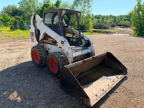 BOBCAT SKID STEER LOADER WITH ENCLOSED CAB, FRONT BUCKET ATTACHMENT, AND HAND/FOOT CONTROLS.