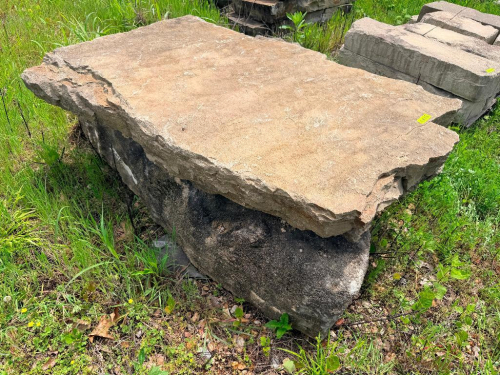 STONE SLAB WITH IRREGULAR CUT EDGES AND WEATHERED SURFACE.