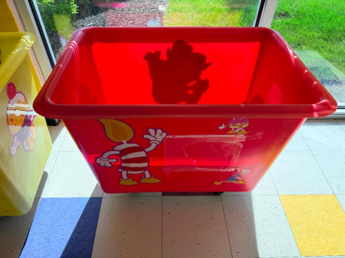 RED PLASTIC HOPPER ON CASTERS.