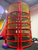 COMMERCIAL INFLATABLE 18 FT SLIDE WITH BLOWER AND ROUND MULTI-LEVEL CLIMBING PLAY STRUCTURE. INCLUDES INFLATABLE SLIDE, BLOWER FAN, METAL FRAME PLAY TOWER, NETTING, AND PADDED SUPPORTS. DISASSEMBLY REQUIRED. - 8