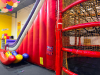 COMMERCIAL INFLATABLE 18 FT SLIDE WITH BLOWER AND ROUND MULTI-LEVEL CLIMBING PLAY STRUCTURE. INCLUDES INFLATABLE SLIDE, BLOWER FAN, METAL FRAME PLAY TOWER, NETTING, AND PADDED SUPPORTS. DISASSEMBLY REQUIRED. - 17