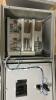 HOFFMAN ELECTRICAL CONTROL PANEL ENCLOSURE WITH PRE-WIRED TERMINAL BLOCKS, DIN RAIL COMPONENTS, STATUS INDICATOR LIGHTS, AND VIEWING WINDOW. STEEL NEMA-TYPE ENCLOSURE WITH LOCKING HANDLE. INTERIOR CONTAINS TERMINAL STRIPS, CIRCUIT PROTECTION COMPONENTS, A - 6