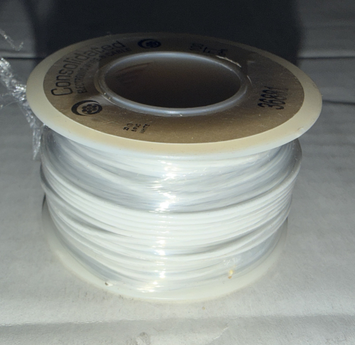 RED PLASTIC TOTE AND CONTENTS - CONSOLIDATED ELECTRONIC WIRE & CABLE FT-4 WHITE HOOKUP WIRE SPOOLS. ASSORTMENT OF PARTIAL AND NEAR-FULL SPOOLS OF INSULATED WHITE ELECTRICAL WIRE SOLD AS A SINGLE LOT.