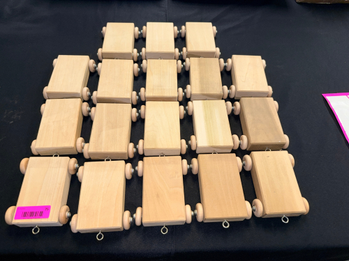 LOT OF WOODEN ROLLING PLATFORM CARS. ASSORTMENT OF UNFINISHED WOODEN CARS WITH FOUR WOODEN WHEELS AND METAL EYELETS, SOLD AS A SINGLE LOT.