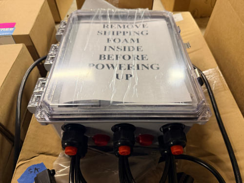 INDUSTRIAL CONTROL ENCLOSURE ASSEMBLY WITH PRE-WIRED CABLES AND CLEAR HINGED COVER. UNIT APPEARS TO BE FACTORY-ASSEMBLED AND INCLUDES MULTIPLE CABLE GLANDS, PRE-INSTALLED WIRING, IEC-STYLE POWER CONNECTION, AND LATCHED TRANSPARENT COVER.