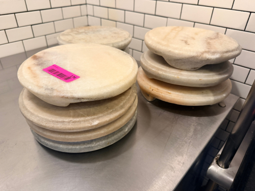 (10) ROUND MARBLE SERVING BOARDS/PEDESTALS IN ASSORTED NATURAL STONE FINISHES. POLISHED STONE CONSTRUCTION WITH INTEGRATED FEET.