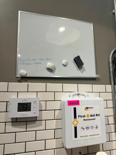 FIRST AID KIT AND SMALL DRY ERASE BOARD.