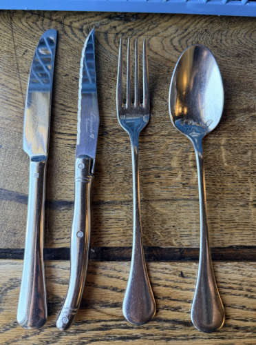 (50) STAINLESS KNIVES, STEAK KNIVES, FORKS, AND SPOONS.