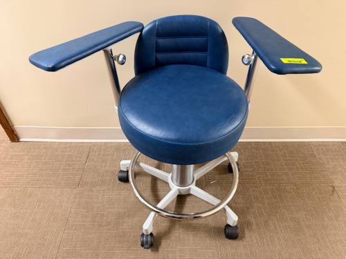 BLUE MEDICAL / OPTOMETRY TECHNICIAN STOOL WITH EXTENDED PADDED ARM RESTS AND ROLLING BASE.