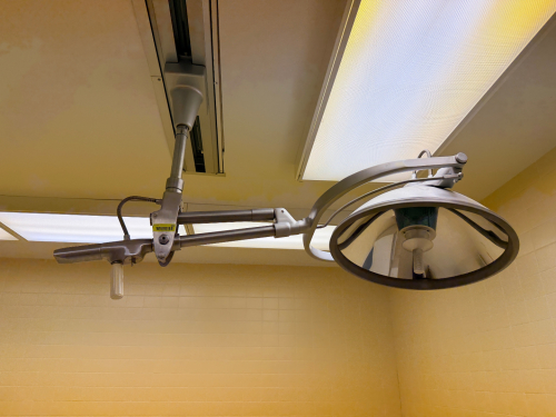 AMERICAN STERILIZER COMPANY (AMSCO) CEILING-MOUNT SURGICAL OPERATING LIGHT / EXAM LIGHT WITH ARTICULATING ARM AND CEILING TRACK MOUNT.