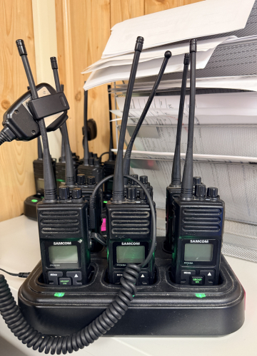 (6) SAMCOM WALKIE TALKIES W/ CHARGING BASE.